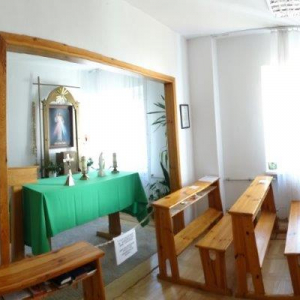 widok kaplicy; na zdjęciu widoczne ławki z klęcznikami, ołtarz, tabernakulum, święte obrazy